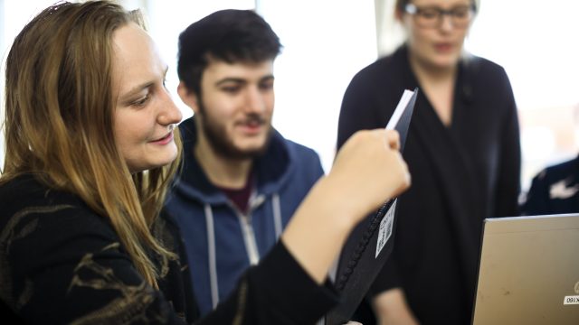 Deltagare Sfi med anteckningsbok och laptop