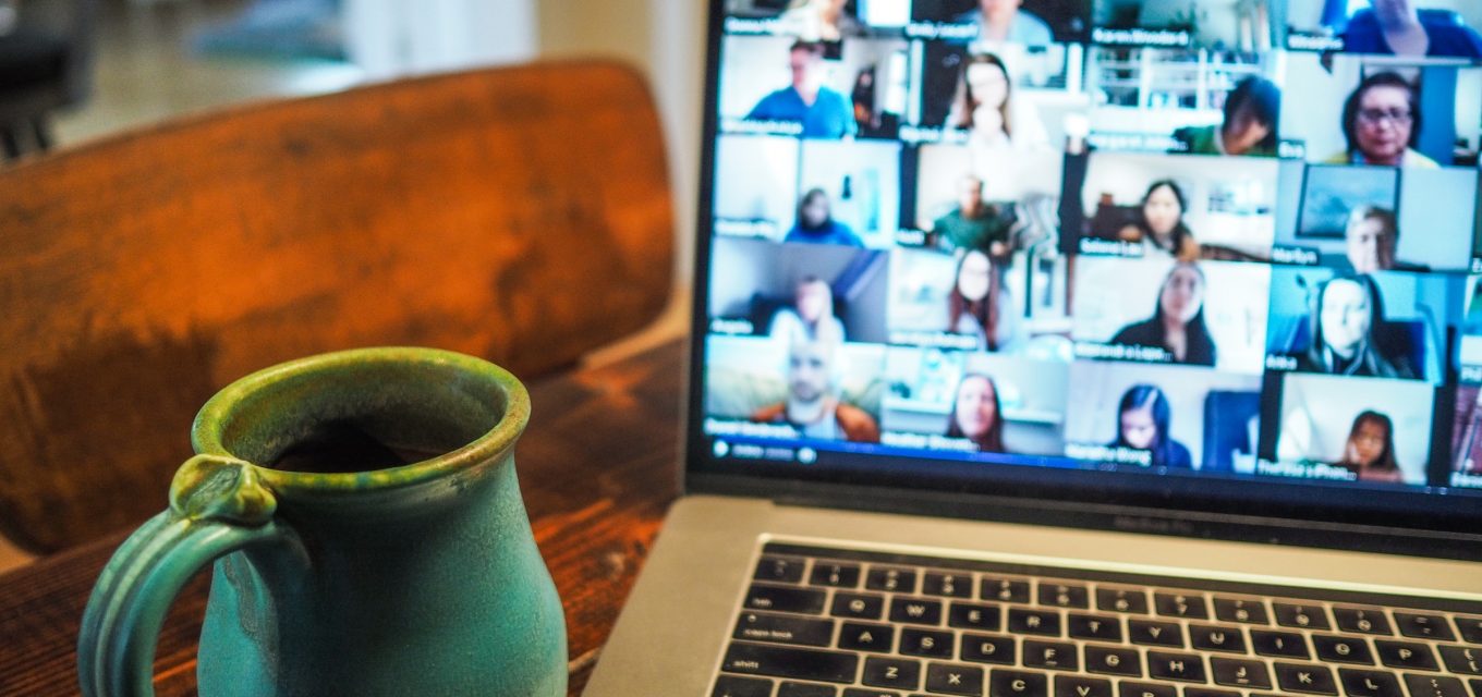 Laptop med digital konferens och kaffekopp