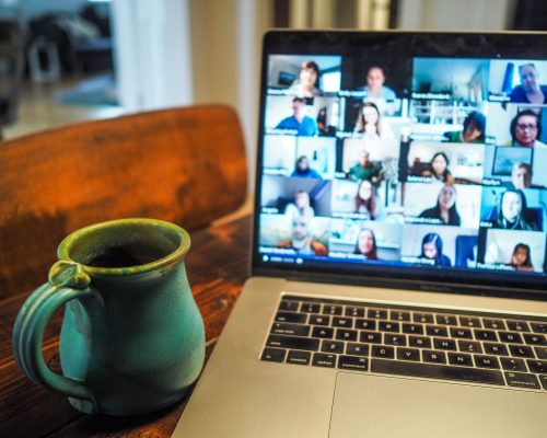 Laptop med digital konferens och kaffekopp