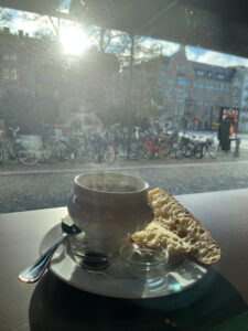 en ångande varm skål soppa på ett fönsterbord med utsikt mot gatan